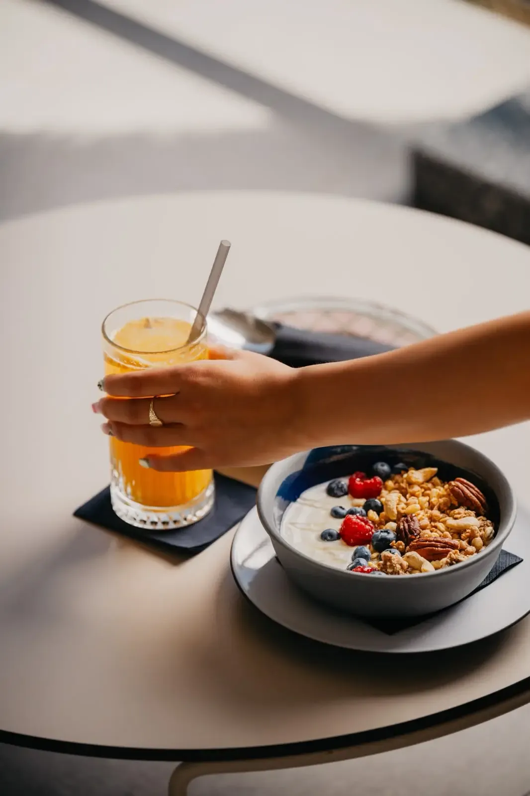 A yogurt, granola and berry breakfast bowl served with orange juice at Central Beach on Žnjan, Split