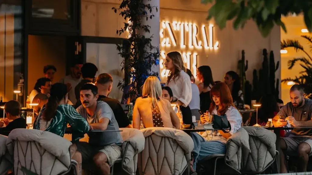 Guests talking over drinks on the terrace at Central Beach Split at golden hour