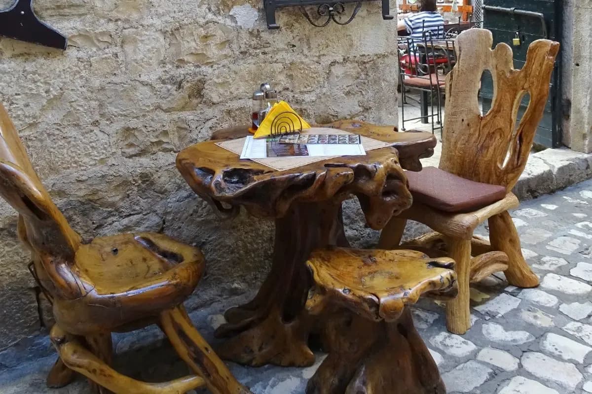 A rustic carved-wood cafe table with a menu in a stone old-town alley in Split, Croatia