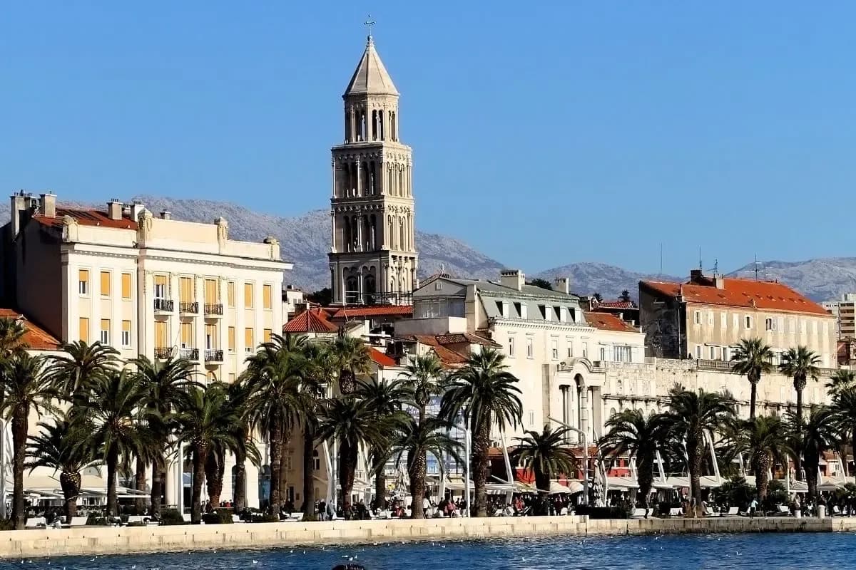 The palm-lined Riva promenade and the cathedral bell tower on the Split waterfront, Croatia